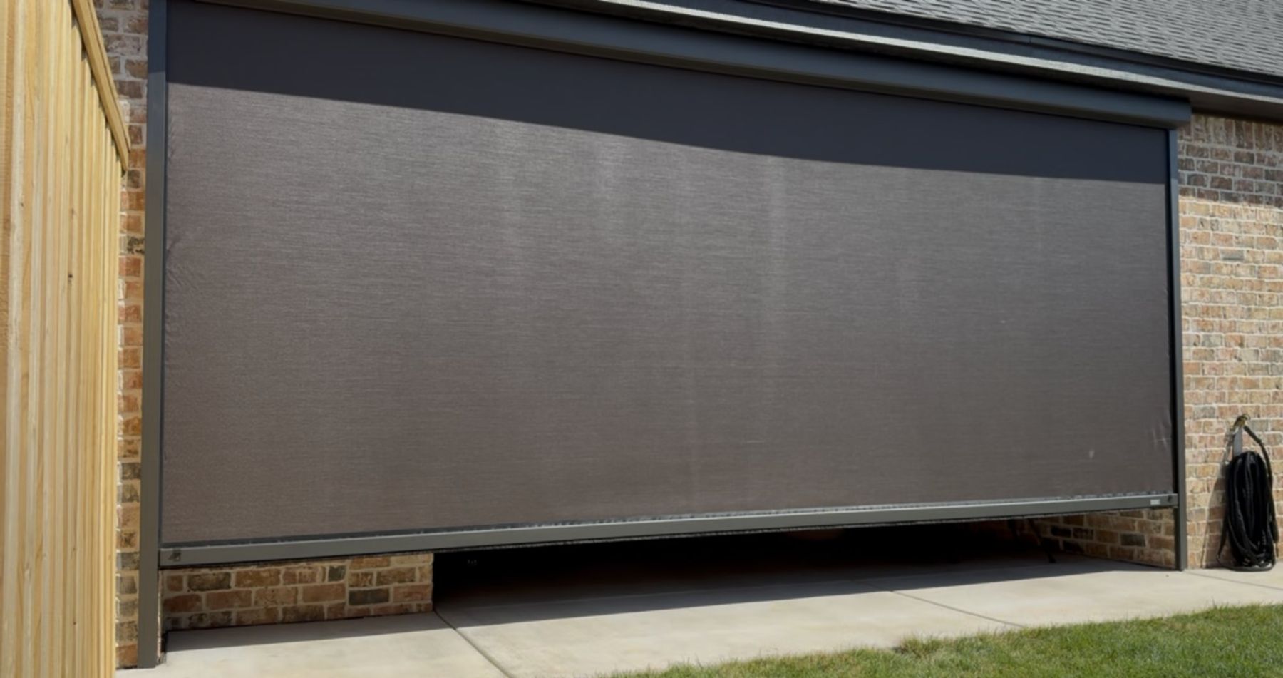Wide screen lowering over a brick patio